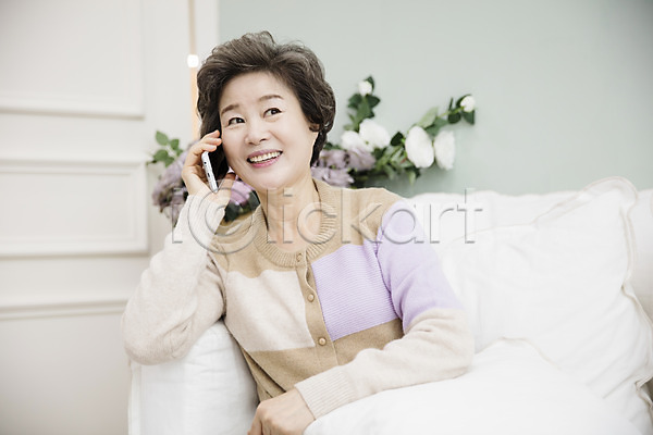휴식 60대 노년 노인여자한명만 여자 한국인 한명 JPG 앞모습 포토 거실 미소(표정) 상반신 소파 스마트폰 실내 실버라이프 앉기 통화 할머니