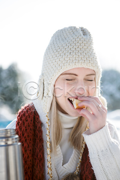 20대 서양인 성인 여자 한명 JPG 포토 겨울 눈감음 들기 먹기 모자(잡화) 목도리 보온병 빵 상반신 야외 웃음 주간 차(음료) 컵