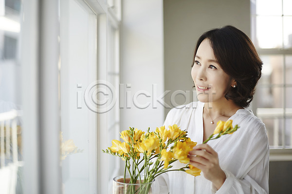 40대 성인 여자 한국인 한명 JPG 아웃포커스 포토 꽃병 상반신 실내 안식처 웃음 응시 중년라이프 창가 프리지어