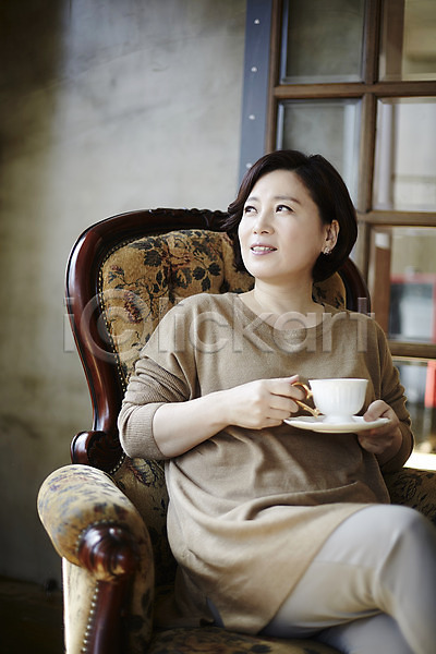티타임 40대 성인 여자 한국인 한명 JPG 포토 다리꼬기 들기 상반신 실내 앉기 웃음 응시 의자 중년라이프 커피 커피잔 컵받침
