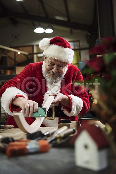 50대 남자 백인 서양인 중년 중년남자한명만 한명 JPG 앞모습 포토 나무 목공소 산타모자 산타옷 산타클로스 상반신 손질 수염 실내 앉기 웃음 작업대 크리스마스