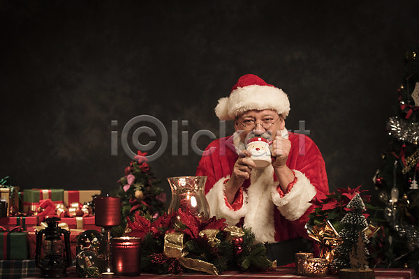 50대 남자 백인 서양인 중년 중년남자한명만 한명 JPG 앞모습 포토 마시기 산타모자 산타옷 산타클로스 상반신 수염 스튜디오촬영 실내 앉기 웃음 크리스마스 크리스마스장식