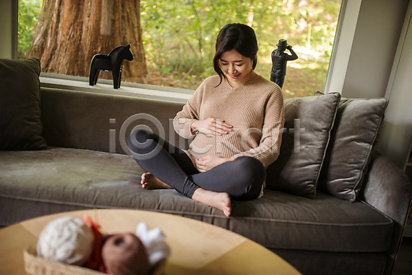 행복 30대 성인 성인여자한명만 여자 한국인 한명 JPG 앞모습 포토 소파 실내 쓰다듬기 앉기 웃음 응시 임산부 임신 전신 쿠션 태교