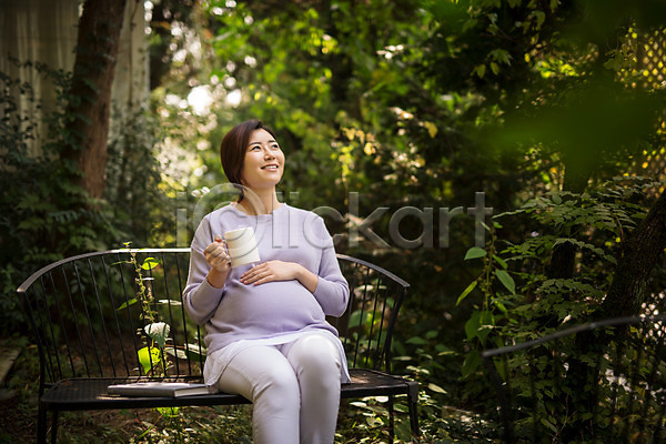 30대 성인 성인여자한명만 여자 한국인 한명 JPG 앞모습 포토 들기 벤치 상반신 숲 숲속 쓰다듬기 앉기 야외 웃음 응시 임산부 임신 주간 커피 태교