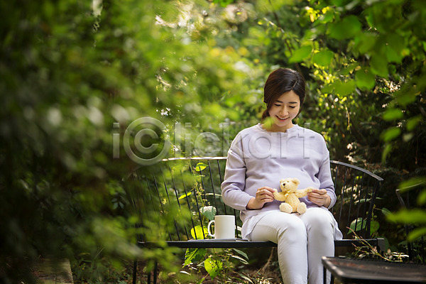 30대 성인 성인여자한명만 여자 한국인 한명 JPG 앞모습 포토 곰인형 머그컵 벤치 상반신 숲 숲속 앉기 야외 웃음 응시 임산부 임신 주간 태교