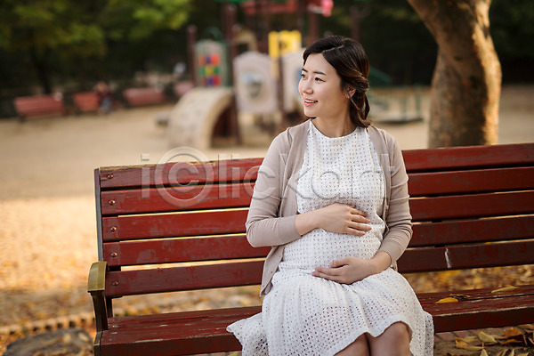 산책 30대 성인 성인여자한명만 여자 한국인 한명 JPG 앞모습 포토 공원 놀이터 벤치 상반신 쓰다듬기 앉기 야외 웃음 응시 임산부 임신 주간 태교